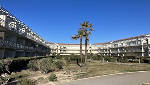 Un hotel a più piani con balconi e un cortile centrale.