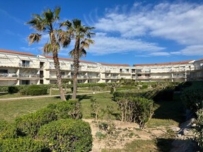 Un hôtel à plusieurs étages, doté de piscines extérieures et bordé de palmiers.