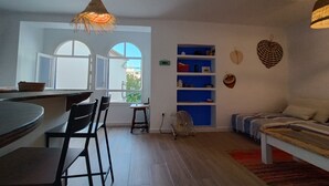 Un espace de vie moderne comprenant un coin cuisine, une table à manger et un espace détente.