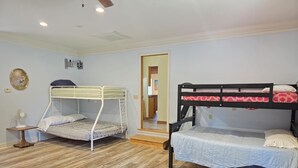 A room with two bunk beds, a small table with a fan, and a wooden floor. - KINGSVIEW -Magnificent Private Lakefront Retreat with Breathtaking Views. (Garfield)