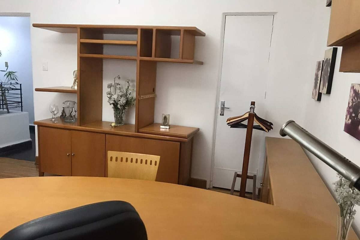 A room with a desk, chair, and a door.