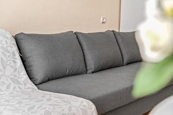 Un canapé gris avec quatre coussins dans un salon.