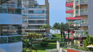 Un hotel moderno de varios pisos con balcones, una zona de piscina y vistas al océano.