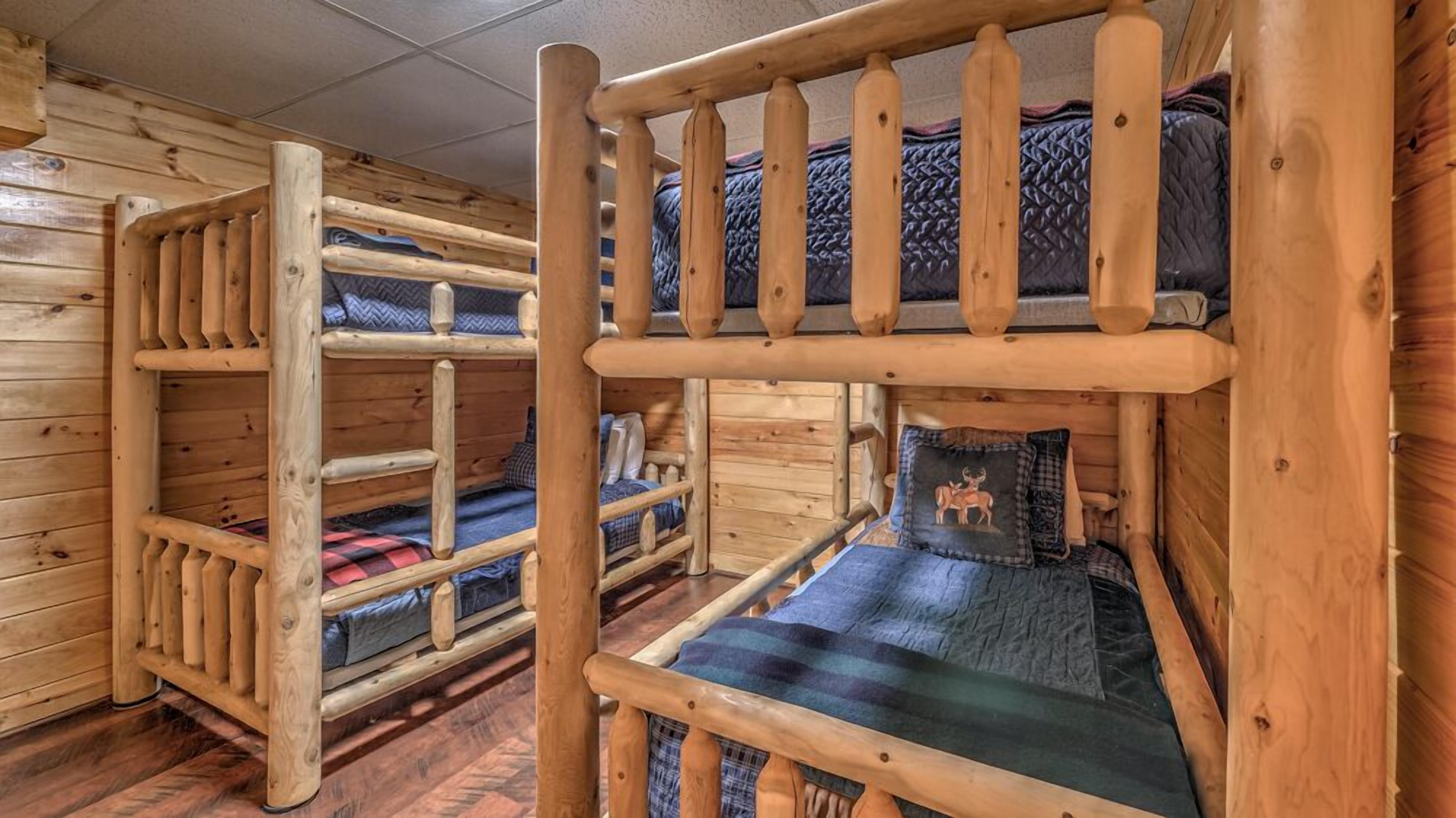 A cabin with wooden bunk beds, each with a mattress and pillows.