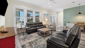 A modern living room with a leather sofa, a wooden coffee table, and a patterned rug. - 🤗 E11G=Awesome! 6BR Beachview. Htd Pools. Easy beach access! (Gulf Shores)