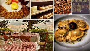 A dining area with checkered tablecloths, wine glasses, and a scenic view. - Historical Tuscan home with  3 bedrooms and 2 baths with beautiful views. (Chianni)