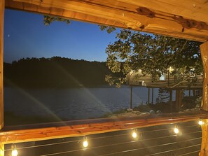 Ein Holzhaus mit Blick auf einen See im Abendlicht.