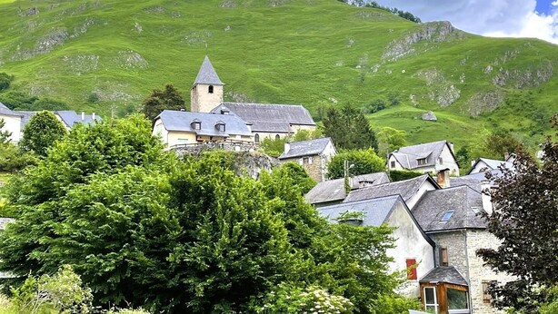 A rural village with stone buildings, a church with a bell tower, and lush green hills in the background. - LE Cailhabas - Lescun (LESCUN)