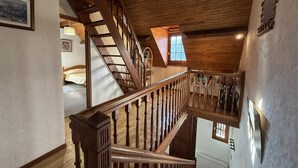 A wooden staircase with a railing, leading to a bedroom with a bed and a window. - LE Cailhabas - Lescun (LESCUN)