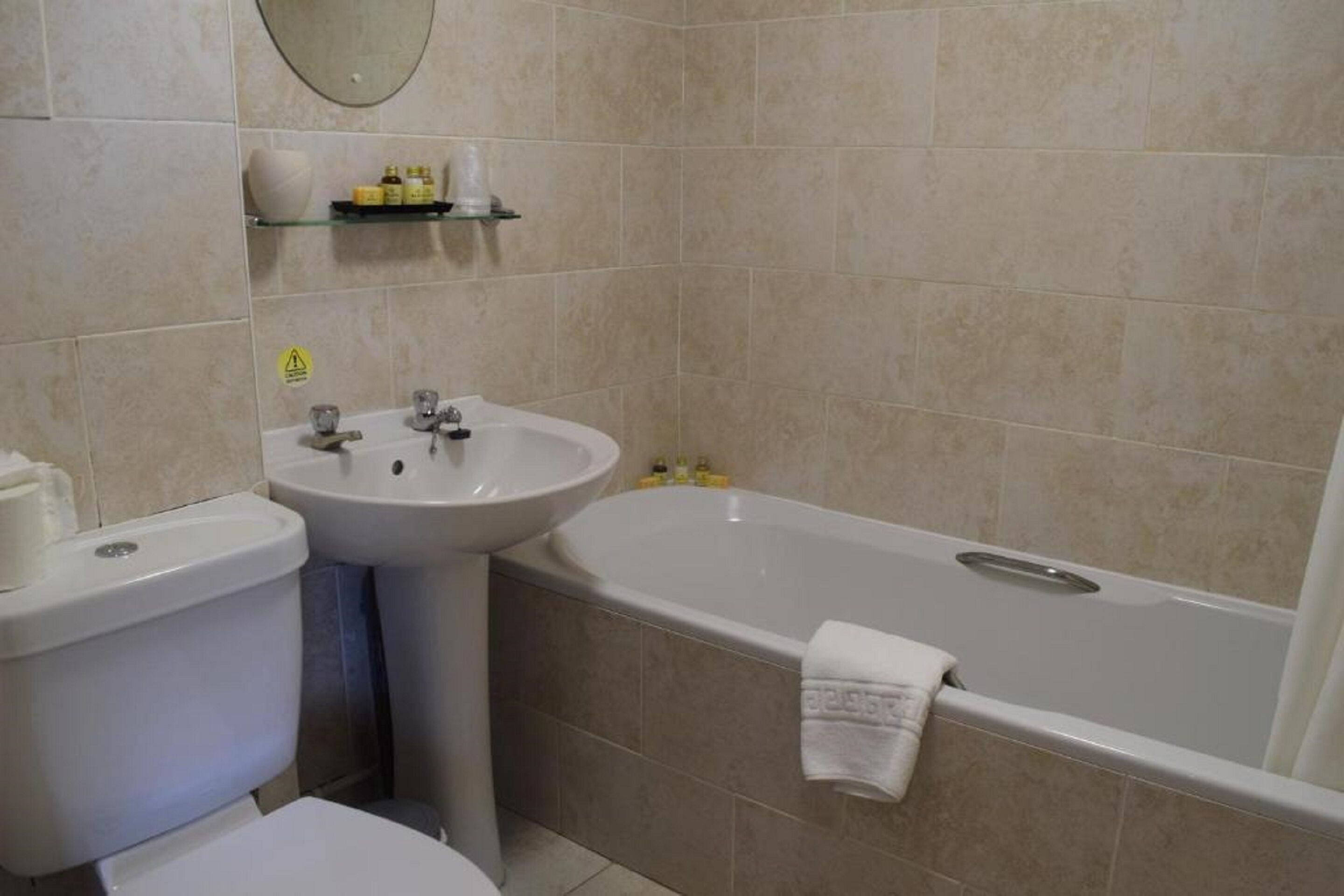 A bathroom with a toilet, sink, and bathtub.
