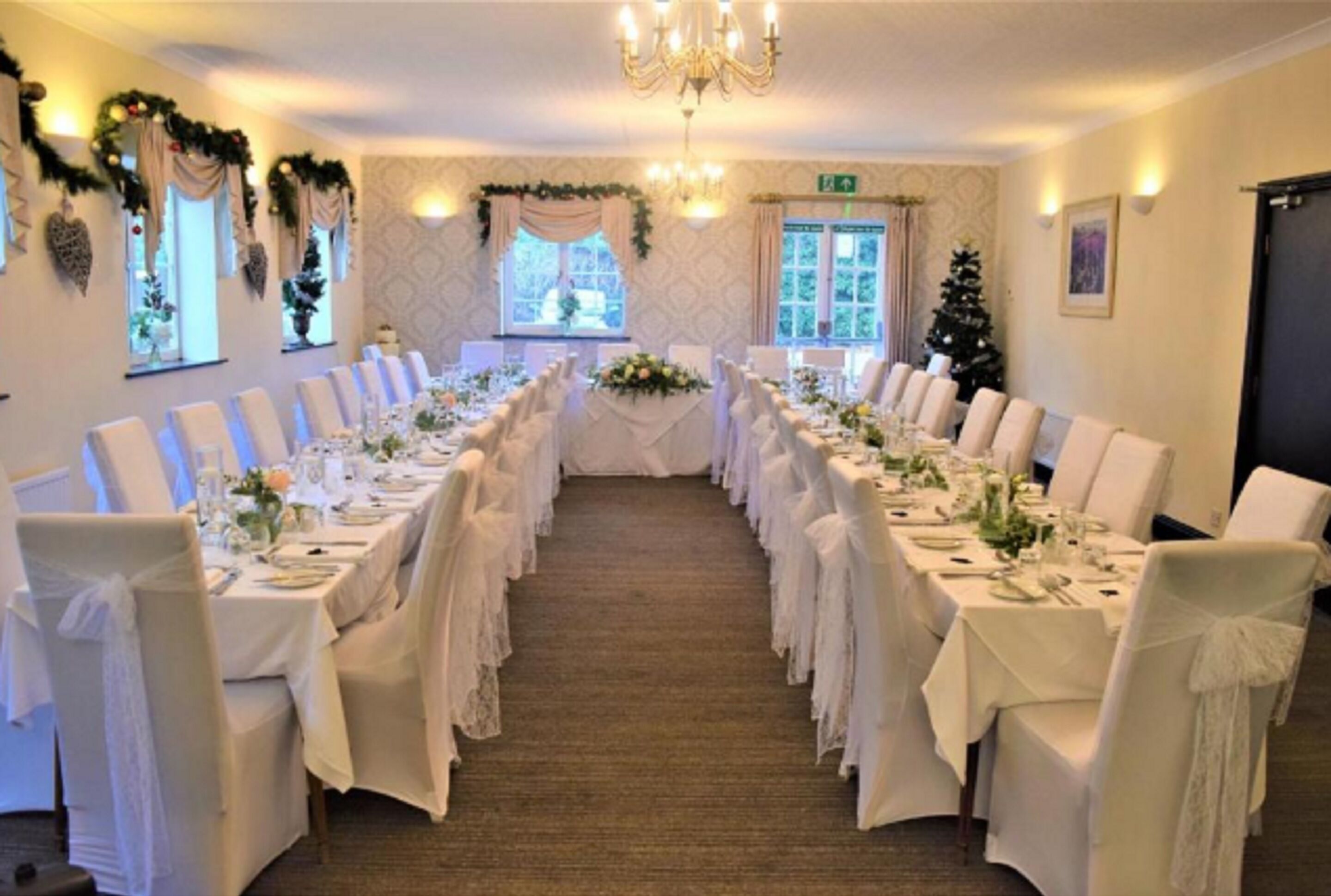 A long banquet table with white tablecloths and chairs, set up for a formal event.