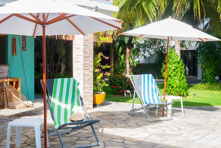 Una piscina al aire libre, sillones reclinables de piscina