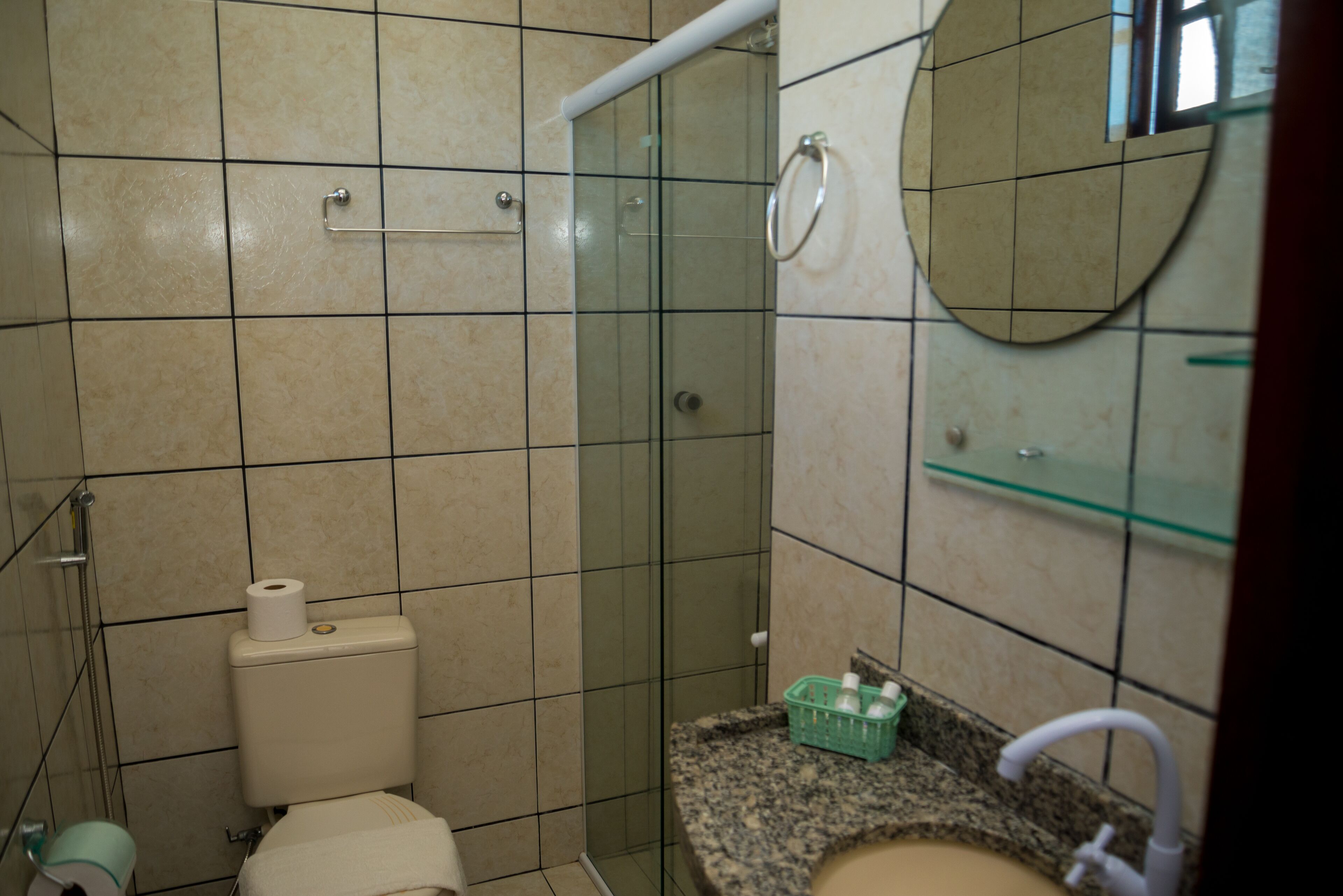 A bathroom with a toilet, shower, and sink.