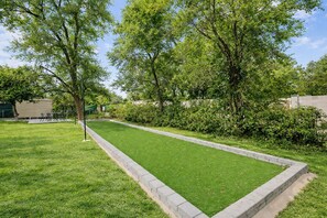 A well-maintained lawn with a croquet court, surrounded by trees and a hedge. - Putt Golf & Hot Tub | By ASU Mill Ave Airport (Tempe)
