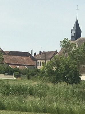A church with a tall steeple and a building with a sloped roof.
