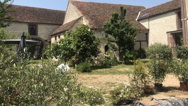 A courtyard with stone buildings, a garden with various plants, and a pergola. - Large Burgundy gîte near Chablis - Auxerre ideal for families & reunions (Valravillon)