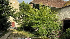 A table set for dining outdoors with a view of a canal and buildings in the background. - Large Burgundy gîte near Chablis - Auxerre ideal for families & reunions (Valravillon)