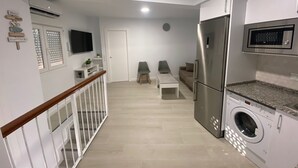 Una cocina moderna con lavadora integrada, un refrigerador y un microondas.