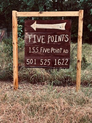 Un panneau de signalisation indiquant la direction à suivre pour se rendre à Five Points, avec l’adresse et le numéro de téléphone.
