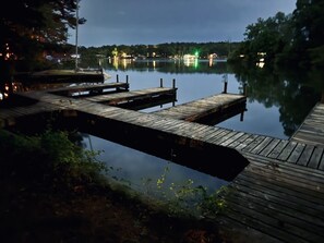 Une jetée en bois s’étendant sur un lac paisible, au crépuscule.