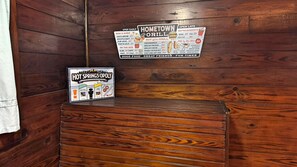 En trævæg med menutavle for Hometown Grill og et skilt for Hot Springs Opoly.