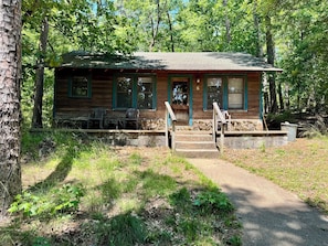 A rustic cabin with a porch, steps, and a bench. - 6-HOT SPRINGS GANGSTER HAVEN - Vintage, Lake View, Swimming, Fishing, Docks, Pet Friendly! (Hot Springs National Park)