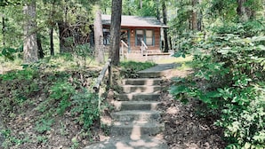 A wooden cabin with a stone staircase leading to a porch.