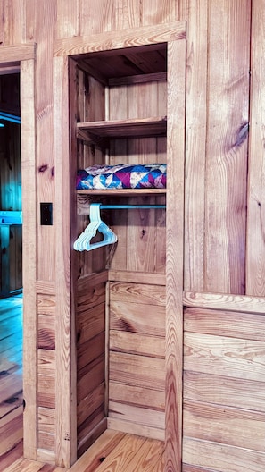 A wooden closet with shelves and a hanging rod.