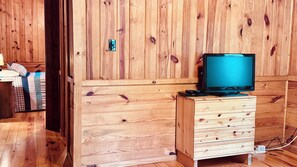 Un meuble en bois avec des tiroirs et un téléviseur posé sur le dessus.