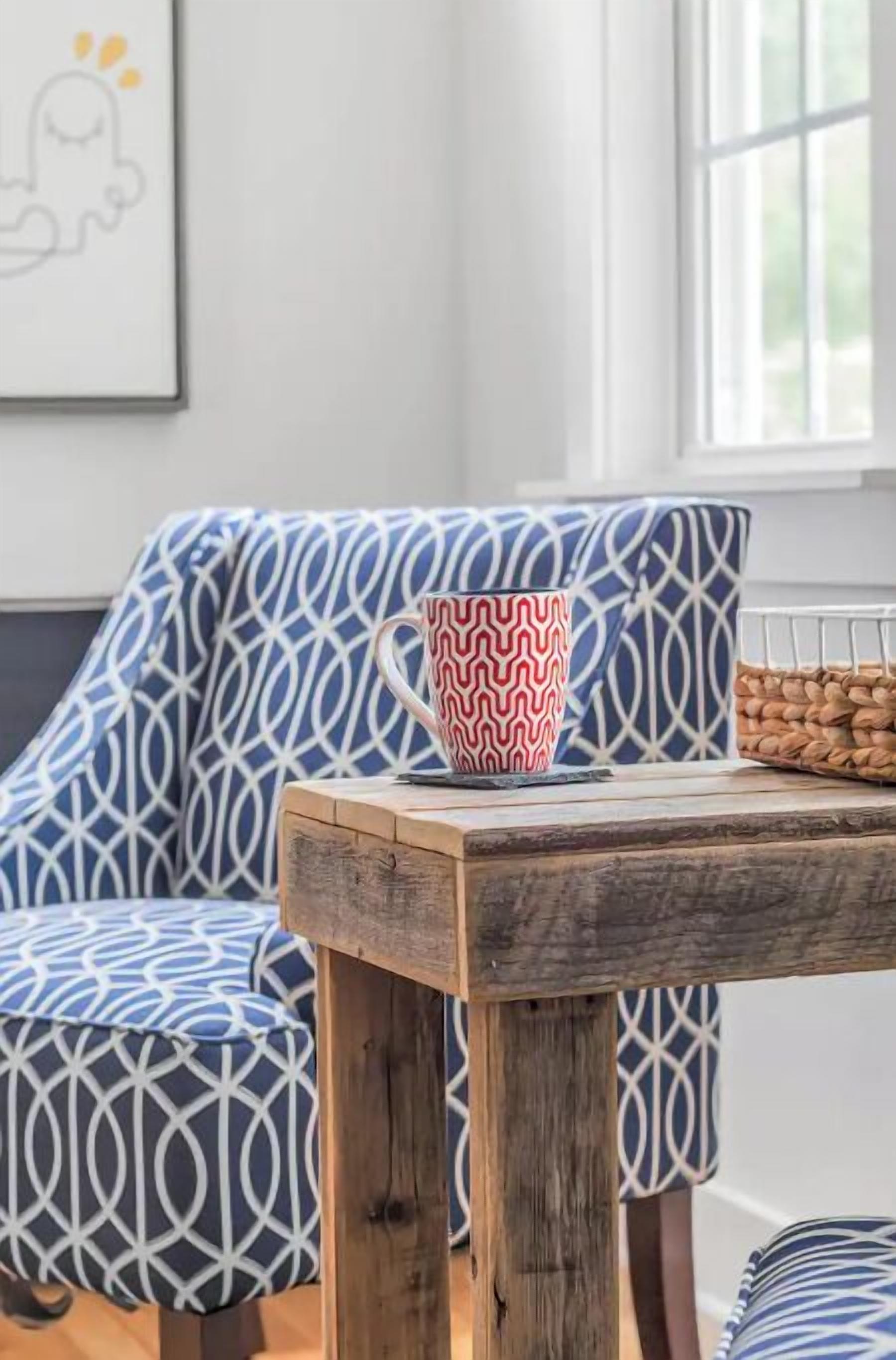 A cozy seating area with a patterned sofa and a wooden table with a mug.