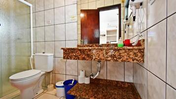 A bathroom with a toilet, sink, and mirror.