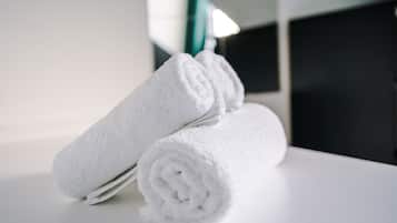 A stack of white towels on a white surface in a room with a modern design.