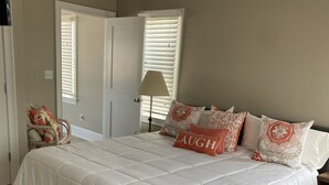 Une chambre à coucher avec un grand lit, une chaise, une lampe et une porte.