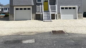 Une maison à deux étages avec un garage, un porche à l’avant et une allée.