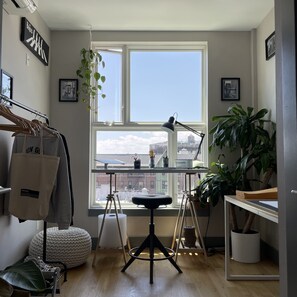 Enjoy a city view from the large window in this stylish room with a comfortable seating area and a desk with a lamp.
