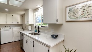 A modern kitchen with white cabinets, a stainless steel sink, and a built-in dishwasher. - Short Walk to Downtown, AC, Coffee Bar, Patio (Enumclaw)
