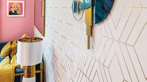 A modern room with a geometric patterned wall, a clock, and a framed picture.