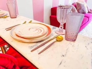 Uma mesa de jantar posta com pratos, talheres e copos.