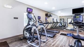A gym with treadmills, elliptical machines, and stationary bikes.