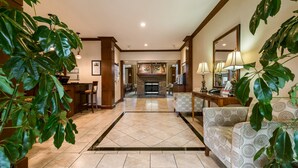 A spacious lobby with a tiled floor, a fireplace, and comfortable seating areas. - Equipped Studio | Top Location, Gym Access + Pool (Gulf Shores)