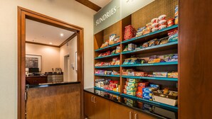 A pantry with shelves stocked with various food items and a sign labeled "SUNDRIES". - Equipped Studio | Top Location, Gym Access + Pool (Gulf Shores)