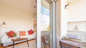 A modern living room with a sofa, coffee table, and a small plant. - GuestReady - Spacious Flat in the heart of Lisbon (Lisbon)