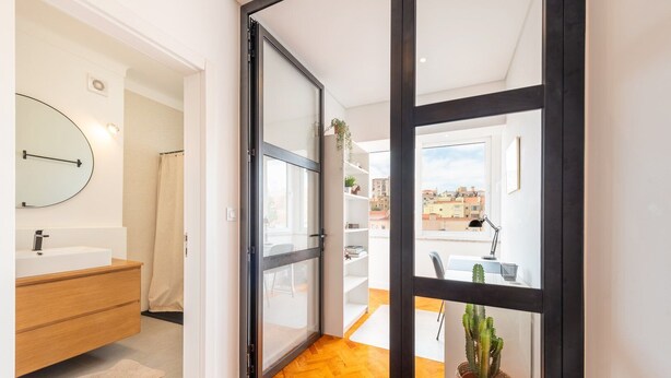 A modern bathroom with a sink, mirror, and wooden vanity. - GuestReady - Spacious Flat in the heart of Lisbon (Lisbon)