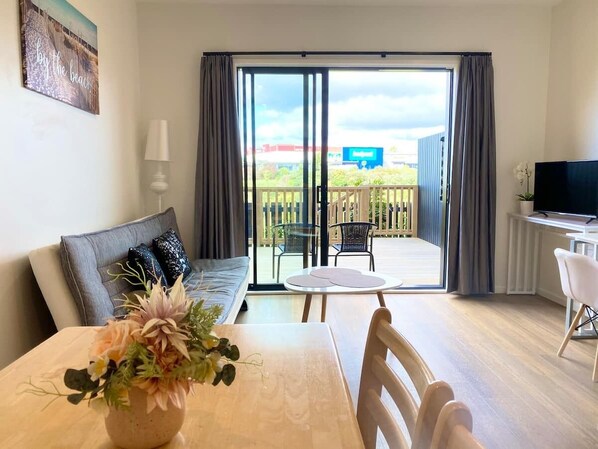 Enjoy a peaceful retreat with a dining table, sofa, and TV in this serene space.