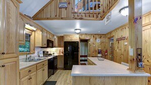 A wooden kitchen with a refrigerator, sink, and cabinets. - Vacation at a family & pet friendly cabin in the Blue Ridge mountains! (Murphy)