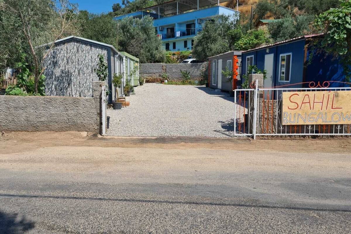 A bungalow with a stone facade, a gravel driveway, and a sign indicating it is a bungalow.