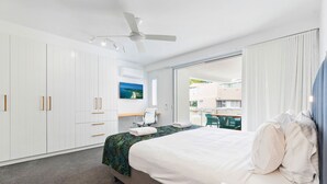 Une chambre d’hôtel moderne avec un grand lit, un bureau et une vue sur l’extérieur.