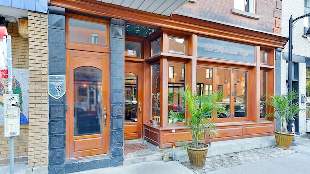 A brick building with large windows and a wooden facade. - La Maison Du Mile-End (Montreal)