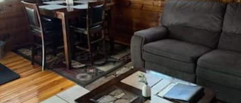 Un interior de madera con comedor, sofá y ventilador de techo.