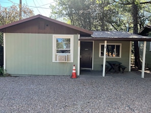 A small, single-story building with a sloped roof, a door, and a window.